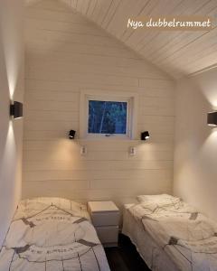 a bedroom with two beds and a window at möja stuga i Stockholms skärgård in Stockholm