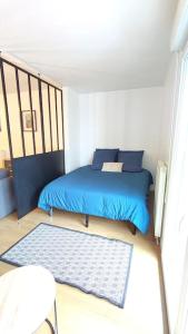 ein kleines Schlafzimmer mit einem blauen Bett und einem Teppich in der Unterkunft Charmant studio à 15 min de Paris in Juvisy-sur-Orge