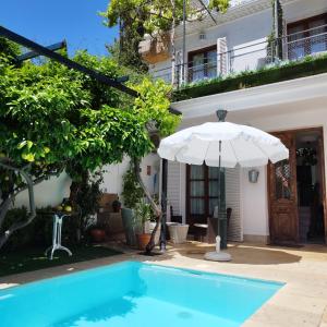 una sombrilla junto a una casa con piscina en Suite Comares en Granada