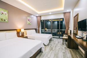 Habitación de hotel con 2 camas y TV en Hệ thống Khách Sạn Sen Biển Sầm Sơn en Sầm Sơn