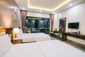 岑山的住宿－Hệ thống Khách Sạn Sen Biển Sầm Sơn，酒店客房设有两张床和电视。