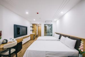岑山的住宿－Hệ thống Khách Sạn Sen Biển Sầm Sơn，一间酒店客房,设有两张床和电视