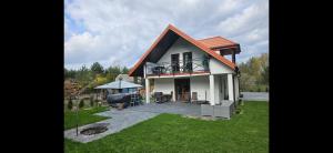 mały dom z balkonem i patio w obiekcie SAN ESCOBAR sauna jezioro Las w mieście Rogowo