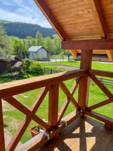 eine Aussicht von der Veranda einer Hütte mit einem Holzdach in der Unterkunft Shum Cheremosha in Werchowyna