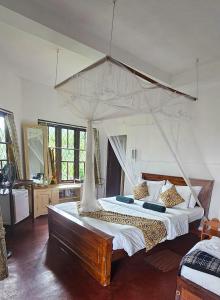 a bedroom with a large bed with a canopy at Hilltop Guest House in Ella