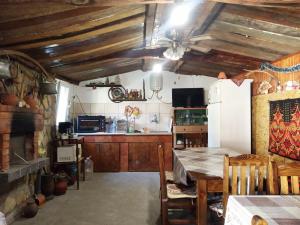 a kitchen with a table and a white refrigerator at Divna Guest House in Krushuna