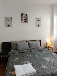 1 cama en un dormitorio con 3 cuadros en la pared en Kings' Palms Residence04, en General Santos