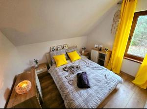 a bedroom with a bed with yellow pillows and a table at SAN ESCOBAR sauna jacuzzi jezioro in Rogowo