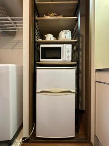 a microwave oven sitting on top of a refrigerator at nestay apartment tokyo ikebukuro in Tokyo
