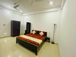 a bedroom with a bed in a white room at Green View Apartments F1 in Varanasi