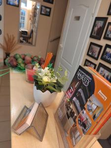 stół z książką i wazonem kwiatów w obiekcie Bed and Breakfast Majesty w Niszu