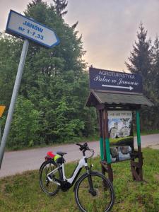 a bike is parked next to a sign at Agroturystyka "Pałac w Janowie" in Janów
