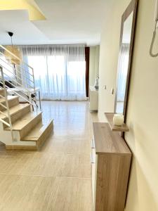 ein Wohnzimmer mit einer Treppe und einem Tisch in der Unterkunft Apartamento Panoramica Golf - Sant Jordi in San Jorge