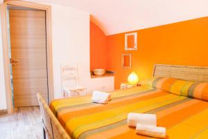 BoscotrecaseにあるVilla Giulia - Vesuvio Guest House Pompei Sorrentoのベッドルーム1室(オレンジ色の壁のベッド2台付)