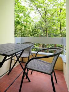 einen Tisch und zwei Stühle auf einem Balkon mit Blick auf die Bäume in der Unterkunft Stupendo monolocale in Minusio