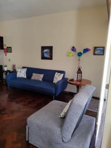 a living room with a blue couch and a table at casa na Torre in Machico
