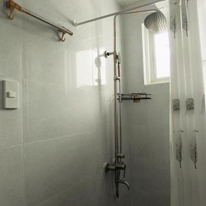 La salle de bains est pourvue d'une douche avec une porte en verre. dans l'établissement Kings' Palms Residence04, à General Santos