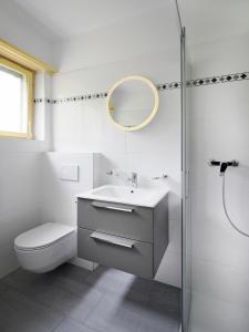 ein Badezimmer mit einem WC, einem Waschbecken und einem Spiegel in der Unterkunft Stupendo monolocale in Minusio