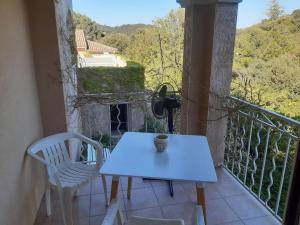 a white table and chairs on a balcony at Au Murmure des Cascades in La Roque-sur-Cèze +8 photos