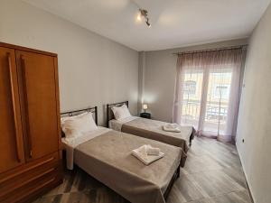 1 dormitorio con 2 camas y ventana en VICTORIA HOUSE, en Kavala