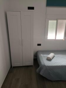 - une chambre avec un lit, une armoire et 2 fenêtres dans l'établissement Casa Daybru, à Ronda