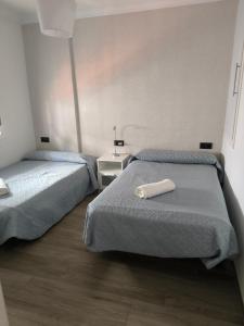 Cette chambre comprend 2 lits et un oreiller blanc sur le lit. dans l'établissement Casa Daybru, à Ronda