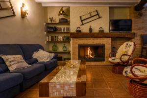 - un salon avec un canapé et une cheminée dans l'établissement Casas Rurales de Vicorto, à Elche de la Sierra