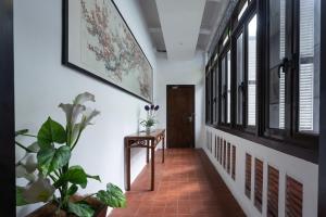 a hallway with windows and a table with plants at Hotel Puri Melaka in Melaka