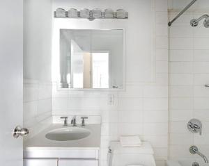 a white bathroom with a sink and a toilet at Lovely 4 BR in NYC! in New York