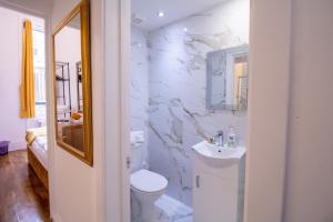 a white bathroom with a toilet and a sink at Selfridges Skyline Suite Located Next to Bond Street in London