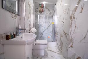 een witte badkamer met een toilet en een wastafel bij Selfridges Skyline Suite Located Next to Bond Street in Londen