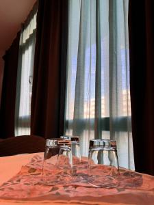 dos copas de vino sentadas en una mesa frente a una ventana en Estelada Boarding Houses en Múnich