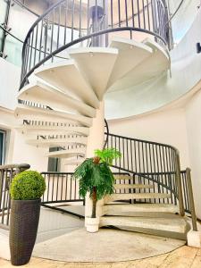 uma escada em espiral num edifício com dois vasos de plantas em Estelada Boarding Houses em Munique