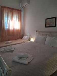 1 dormitorio con 2 toallas en una cama con ventana en Flisvos Home Studio, en Megalochori