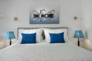 una camera da letto con un letto bianco con cuscini blu di Skinopi Fisherman's Dream a Schinopi