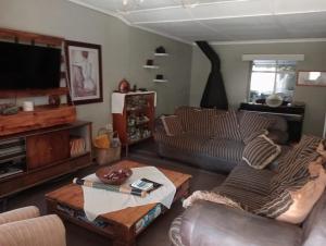 un soggiorno con un divano e una TV di Campbell Stays a Kestell
