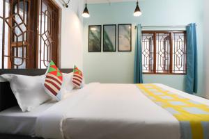 uma grande cama branca num quarto com janelas em Super OYO JANAPATH INN em Khandagiri