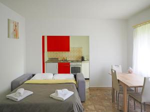 Zimmer mit 2 Betten, einem Tisch und einer Küche in der Unterkunft Stupendo monolocale in Minusio
