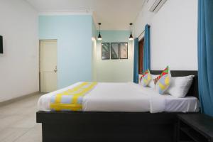 Schlafzimmer mit einem Kingsize-Bett und bunten Kissen in der Unterkunft Super OYO JANAPATH INN in Khandagiri
