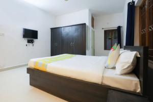 Super OYO JANAPATH INN في Khandagiri: غرفة نوم بسرير كبير وتلفزيون