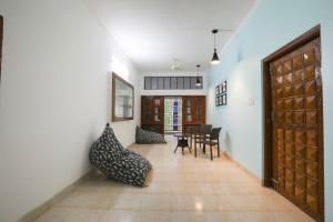 a hallway with a table and chairs and a door at Super OYO JANAPATH INN in Khandagiri