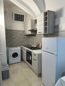 uma cozinha com um frigorífico branco e uma máquina de lavar louça em L'Albero della Vita em Catânia