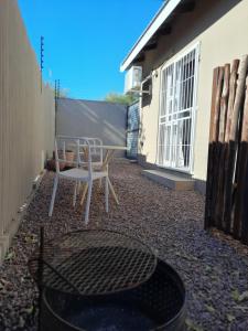 a patio with two chairs and a trash can at Allegro Guest House in Prieska