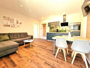 a living room with a couch and a table and chairs at Bett und Bike Bergen in Elsterheide