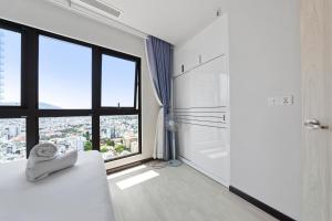 a white bathroom with a shower and a large window at De' Lora GoldCoast Apartment in Nha Trang