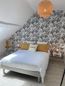 1 dormitorio con 1 cama con papel pintado en blanco y negro en Chez Pat&Fred, en Balnot-la-Grange
