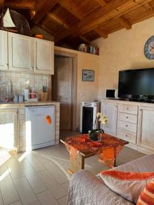 a kitchen with a table and a tv in it at Casetta Vittoria in Palau +14 photos