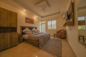 a bedroom with a bed and a chair in it at PerfectStayz B2L Hills Tapovan in Rishīkesh