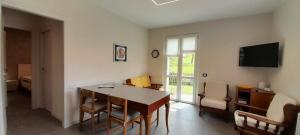 a living room with a table and chairs and a television at La Tita in Somendenna