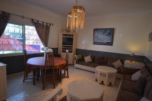 ein Wohnzimmer mit einem Sofa und einem Tisch in der Unterkunft Les appartements de la Villa Beida in Oualidia